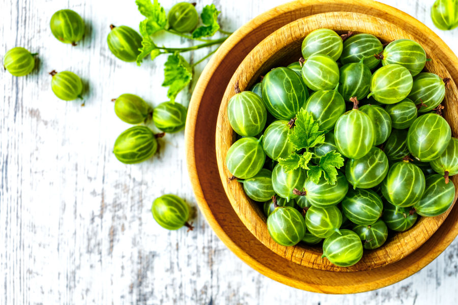 Holzschüssel mit Stachelbeeren