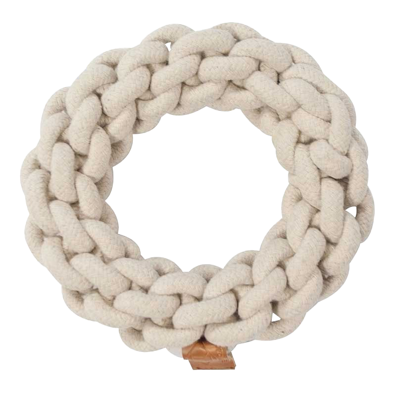Rundes Hundespielzeug aus dickem, geflochtenem, cremefarbenem Seil mit kleinem Lederetikett am unteren Rand.