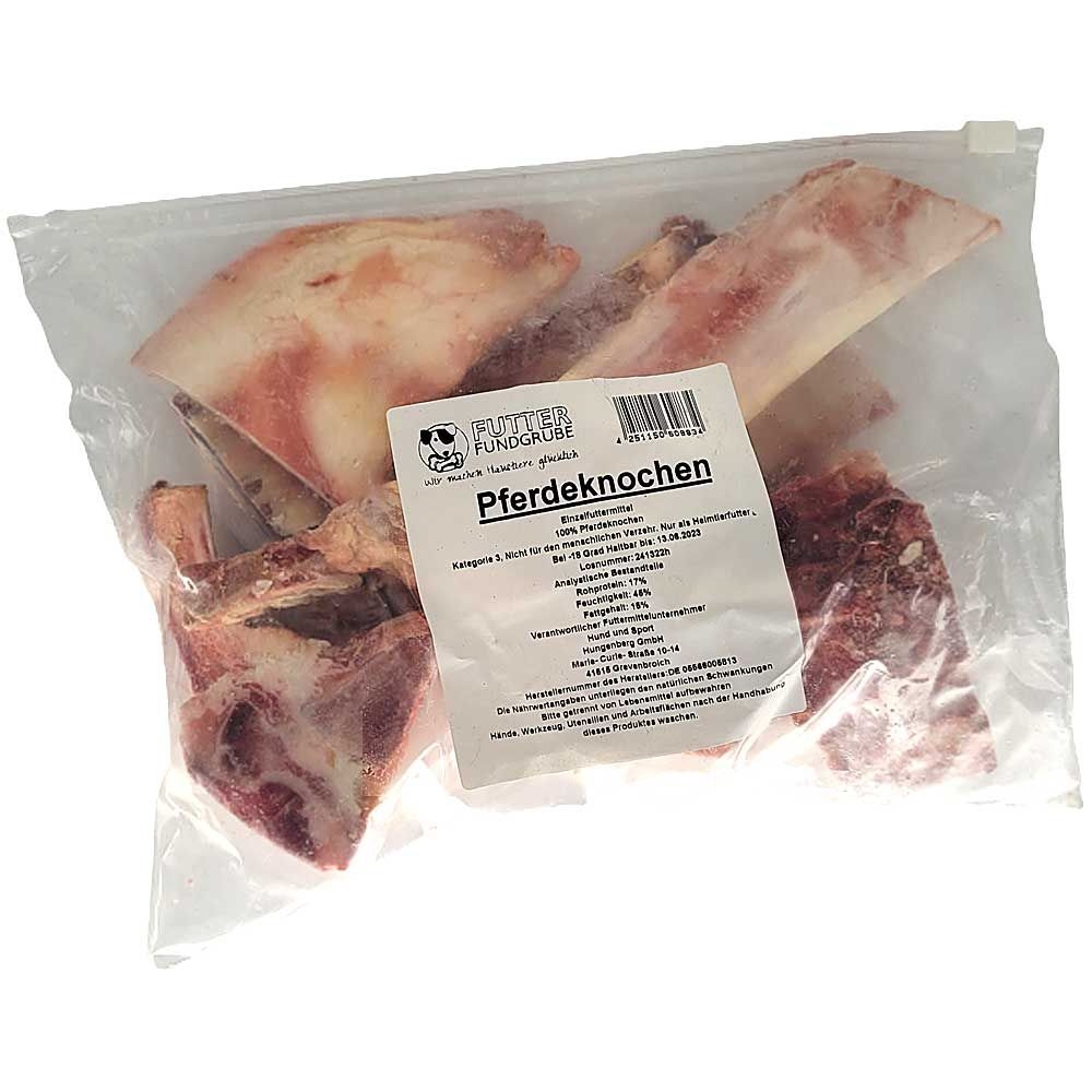 Pferdeknochen 1 kg Ein transparenter Beutel mit unterschiedlich großen, teils fleischigen Pferdeknochen in hellem bis rötlichem Farbton. Auf der Vorderseite befindet sich ein weißes Etikett.