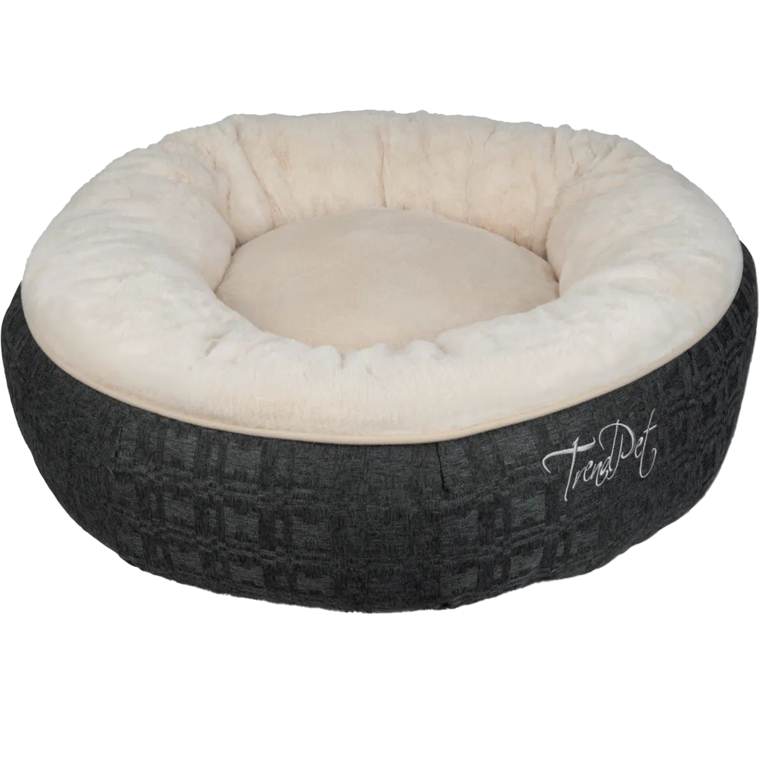 Ein rundes Haustierbett mit breitem, weichem Rand aus cremefarbenem Plüsch. Die Außenwand ist dunkelgrau mit dezenter Struktur und gesticktem „TrendPet“-Schriftzug