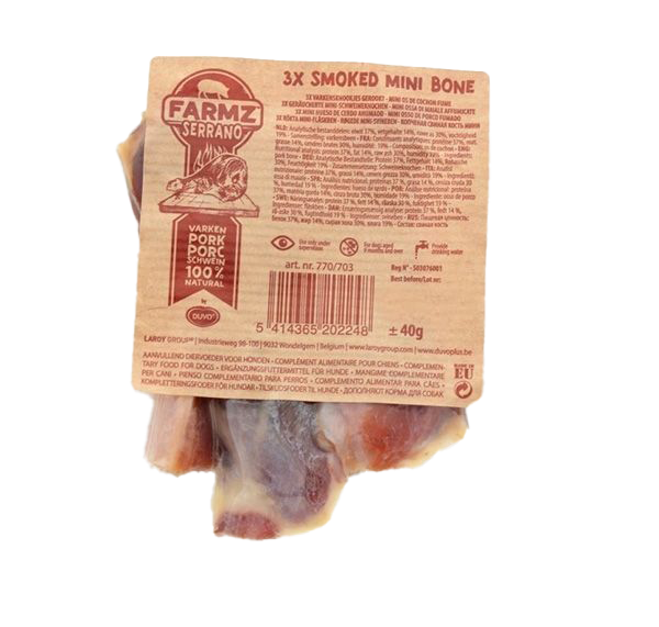 Drei kleine, geräucherte Schweineknochen in transparenter Vakuumverpackung. Die Knochen sind unregelmäßig geformt, braun bis rötlich gefärbt mit teils glänzender Oberfläche.