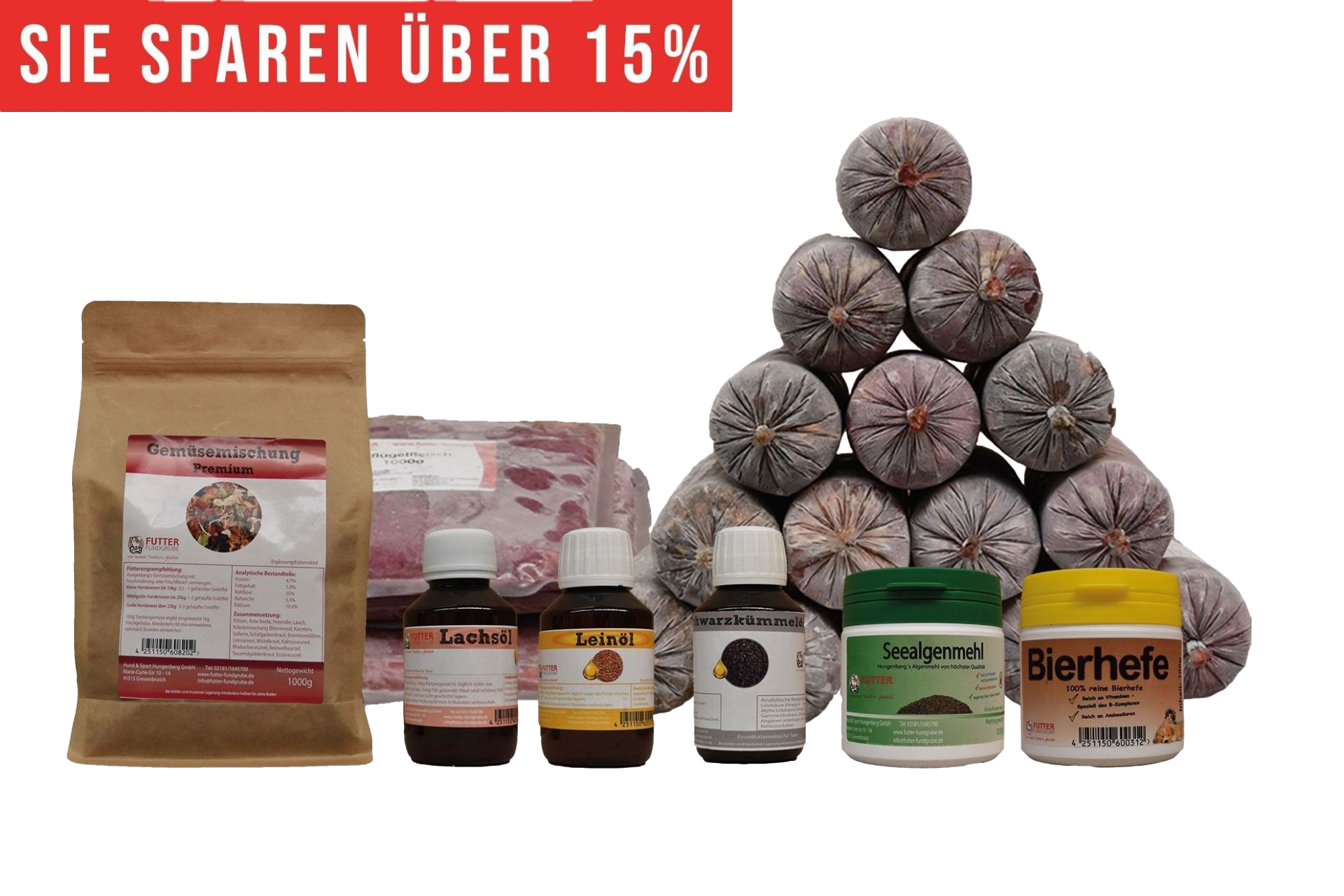 Ein vielseitiges BARF-Paket mit pyramidenförmig gestapelten Frostfleischrollen in grauem Kunstdarm. Davor stehen Flachbeutel mit rotem Inhalt, ein brauner Standbeutel, vier kleine Fläschchen und zwei Dosen.