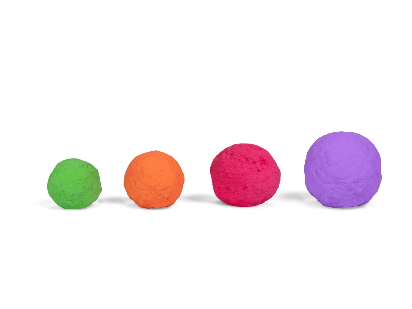 Vier unterschiedlich große Bälle aus Naturkautschuk in Grün, Orange, Pink und Lila auf weißem Hintergrund