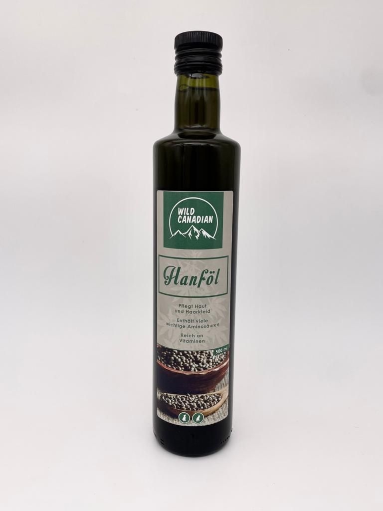 Eine dunkle Glasflasche mit schwarzem Schraubverschluss und grünem Etikett der Marke ‚Wild Canadian‘. Beschriftet mit ‚Hanföl‘ und bebildert mit Hanfsamen.