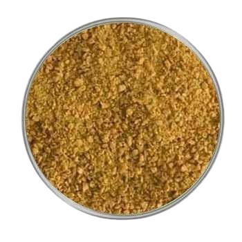 Ein kreisrunder Behälter mit grob gemahlenem, goldbraunem Pulver. Die Struktur wirkt krümelig und unregelmäßig, die Farbe ist warm und leicht rötlich.