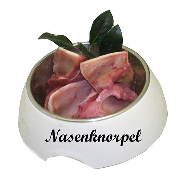 Ein weißer Napf, gefüllt mit mehreren Stücken rohem Nasenknorpel. Das Fleisch ist rosarot mit glatten Schnittflächen. Obenauf liegen grüne Blätter als Dekoration.