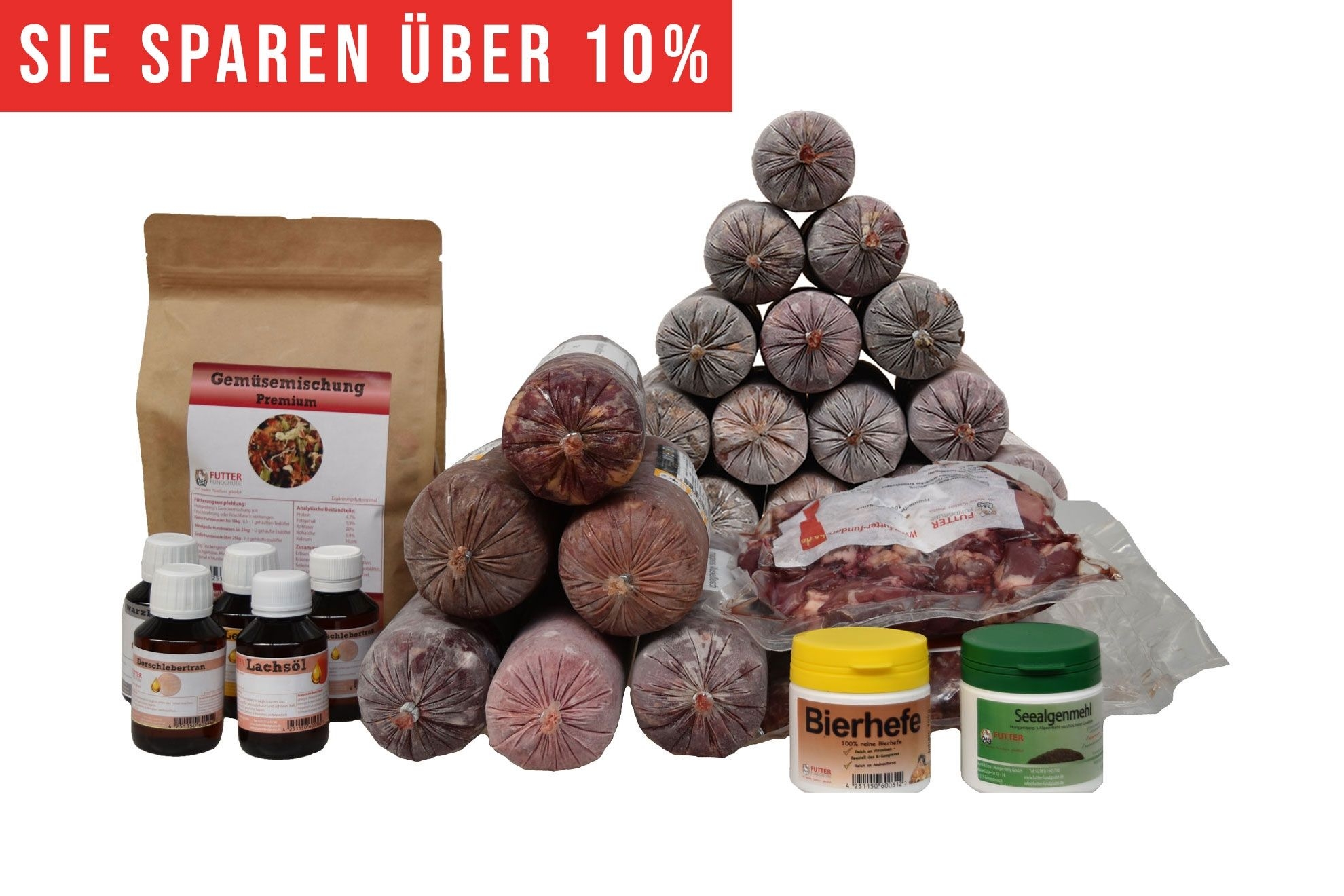 Ein vielseitiges BARF-Paket mit pyramidenförmig gestapelten Frostfleischrollen in grauem Kunstdarm. Davor stehen Flachbeutel mit rotem Inhalt, ein brauner Standbeutel, fünf kleine Fläschchen und zwei Dosen.
