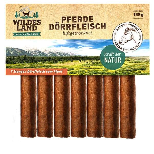 Verpackung mit Hundesnacks, illustriert mit einer Landschaft aus Bergen und Feldern. Im Vordergrund sind längliche Fleischsticks zu sehen.