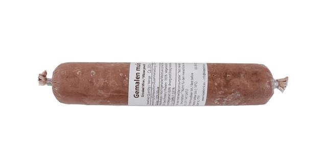 Eine Frostfleischrolle mit weißem Etikett und der Aufschrift „Gemahlen mit Knochen“. Verpackt in einem nicht essbaren Kunstdarm. Die Füllung ist fein gewolft und hellbraun gefärbt.
