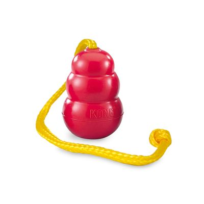 Rotes Hundespielzeug in klassischer KONG-Form mit drei runden Segmenten. Oben befestigt ist eine gelbe, geflochtene Schnur. Oberfläche wirkt glatt und robust.