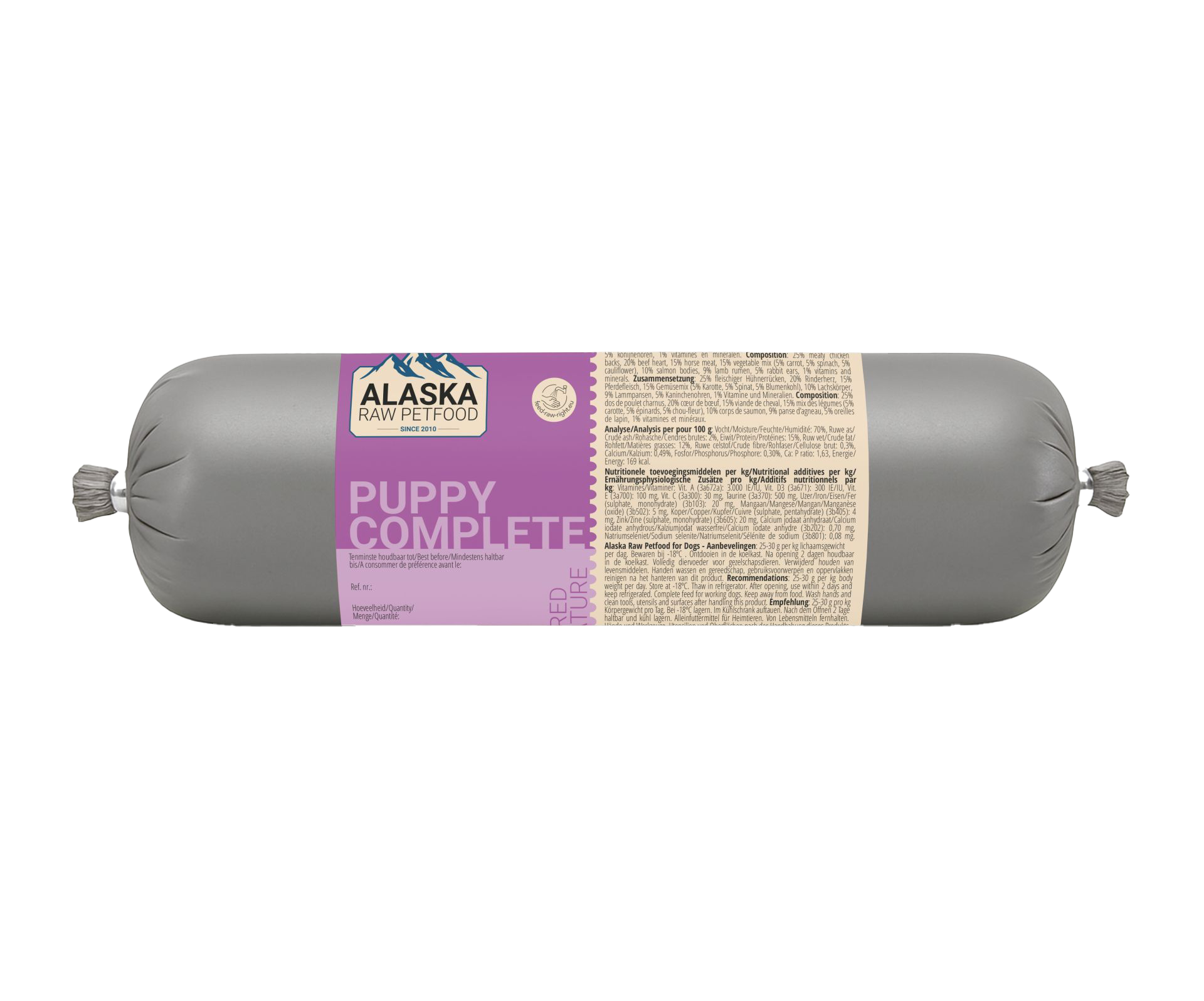 Eine graue Frostfleischrolle mit violettem Etikett ‚Puppy Complete‘, verpackt in nicht essbarem Kunstdarm; rechts befindet sich ein beiges Informationsetikett mit Text.
