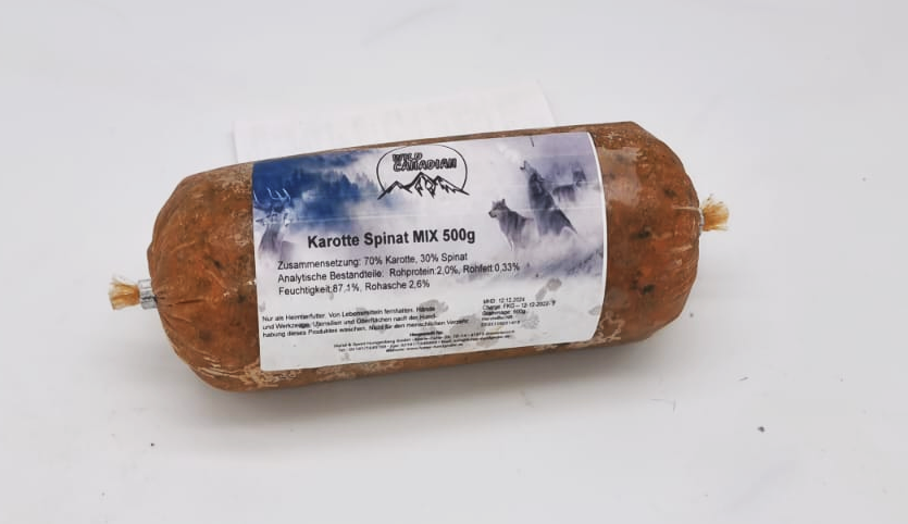 Eine Frostfleischrolle mit weißem Etikett und der Aufschrift „Karotte Spinat MIX“. Verpackt in einem nicht essbaren Kunstdarm. Die Füllung ist orange-braun mit sichtbaren dunkelgrünen Einschlüssen.