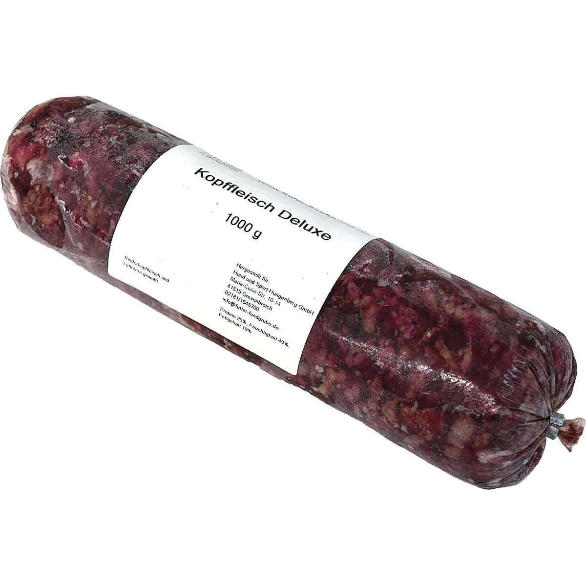 Eine Frostfleischrolle mit weißem Etikett und der Aufschrift „Kopffleisch Deluxe“. Verpackt in einem nicht essbaren Kunstdarm. Die Füllung ist grob gewolft und zeigt eine dunkelrot-marmorierte Farbe mit sichtbaren Fett- und Knorpelstücken.