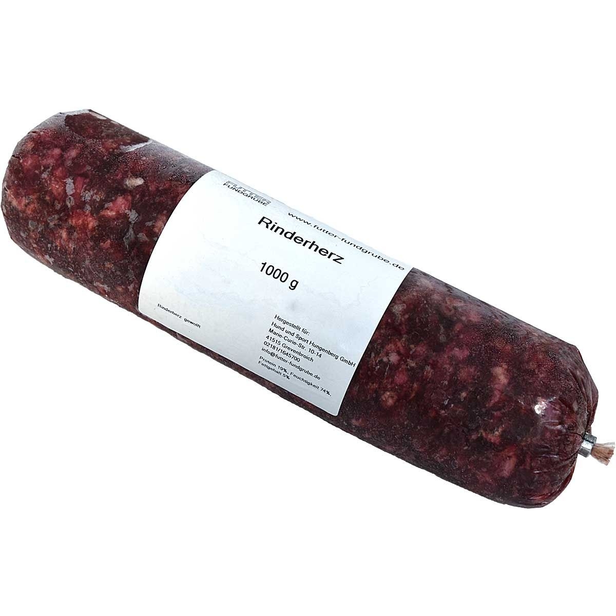 Eine Frostfleischrolle mit weißem Etikett und der Aufschrift „Rinderherz“. Verpackt in einem nicht essbaren Kunstdarm. Die Füllung ist fein gewolft und tief dunkelrot mit kleinen hellen Stücken.