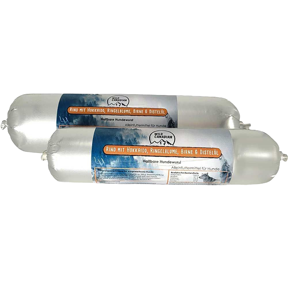 Zwei haltbare Hundewürste in glänzend silberner Kunststoffhülle. Auf dem Etikett steht „Rind mit Hokkaido, Ringelblume, Birne & Distelöl“. Die Verpackung zeigt ein Bergpanorama mit Waldmotiv.