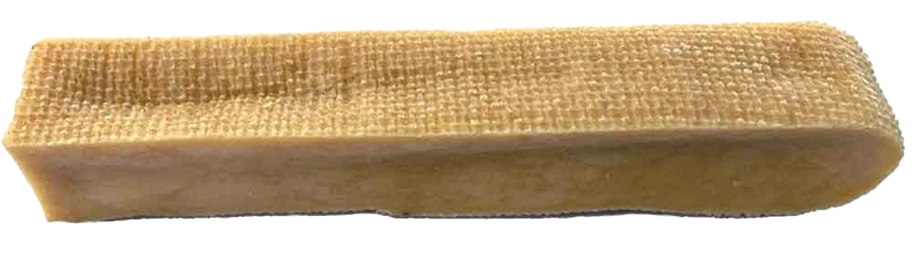 Ein naturfarbener, fester Kausnack in länglicher Riegelform mit rauer, strukturierter Oberfläche und glatten Seitenrändern.