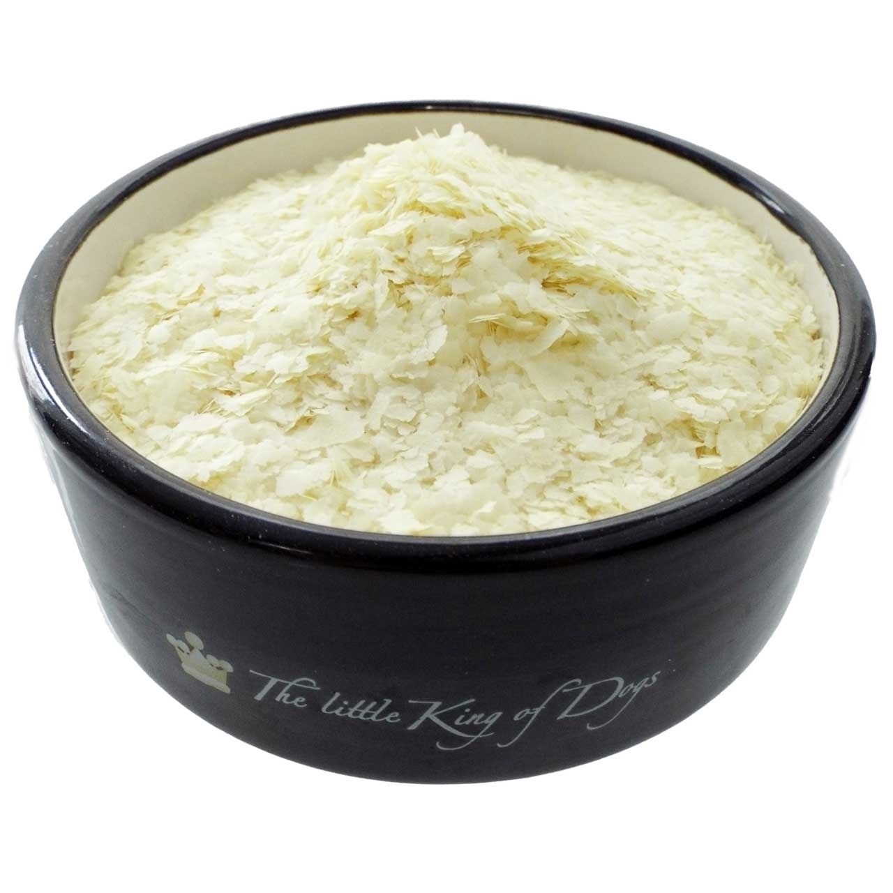 Kraft & Fitness-Mischung 2 kg Eine schwarze Futterschale mit einer hellgelben, flockigen Mischung. Die „Kraft & Fitness“-Flocken sind fein, hauchdünn und unregelmäßig geformt.