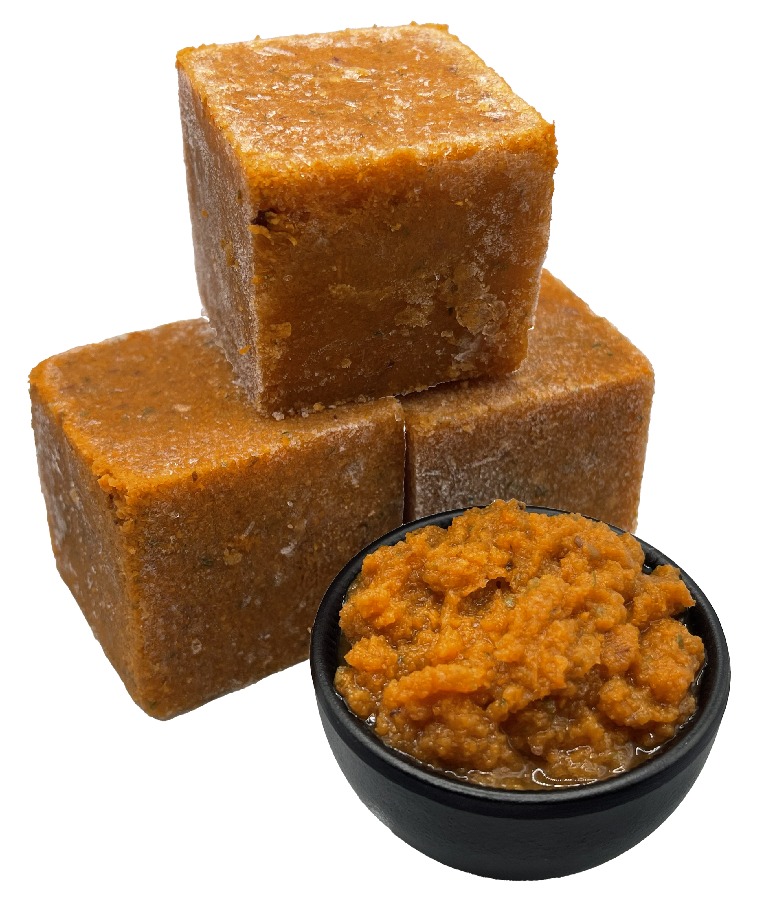 Regenbogen Gemüse- Obstmix 1000g Drei gefrorene, orangebraune Würfel aus püriertem Gemüse. Daneben steht eine schwarze Schale mit aufgetauter, stückiger Gemüsemasse in kräftigem Orange.