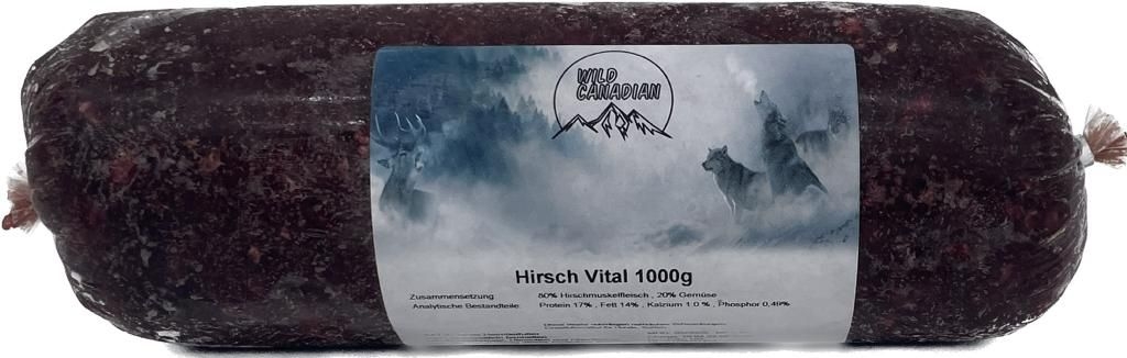 Wild Canadian Hirsch Vitalmix 1000g Eine Frostfleischrolle mit weiß-blauem Etikett und der Aufschrift „Hirsch Vital 1000 g“. Verpackt in einem nicht essbaren Kunstdarm. Die Füllung ist fein gewolft und dunkelrot.