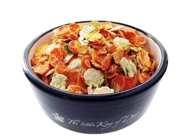 Eine dunkelblaue Futterschale mit bunter Gemüseflockenmischung aus groben, getrockneten Scheiben in Orange, Hellgrün, Beige und Gelb, überwiegend flach und gewölbt.