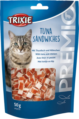 Eine aufrechte, blau gestaltete Beutelverpackung mit Katzenabbildung, transparentem Sichtfenster und zweifarbigen Snackstücken in Würfelform aus Thunfisch und hellem Fleisch, locker geschichtet.