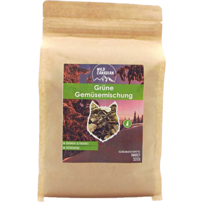 Ein brauner Papierbeutel mit grünem Etikett der Marke „Wild Canadian“. Aufschrift „Grüne Gemüse­mischung“, Sichtfenster zeigt grüne, blättrige Gemüseflocken.