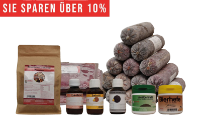 Ein vielseitiges BARF-Paket mit pyramidenförmig gestapelten Frostfleischrollen in grauem Kunstdarm. Davor stehen Flachbeutel mit rotem Inhalt, ein brauner Standbeutel, vier kleine Fläschchen und zwei Dosen.