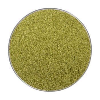 Weizengras Pulver 200 g Ein rundes Sichtfenster mit fein gemahlenem, gelblich-grünem Pulver mit gleichmäßiger, sandartiger Struktur und matter Oberfläche.