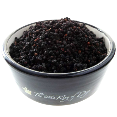 Ein dunkelblauer Napf, gefüllt mit kleinen, schwarzen bis dunkelvioletten Trockenbeeren mit leicht runzliger Oberfläche, kuppelförmig aufgeschichtet.