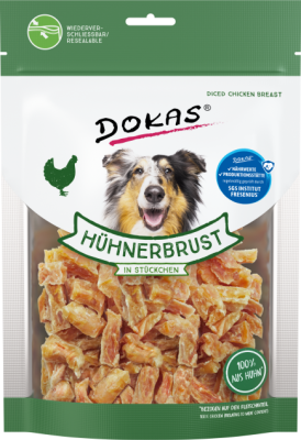 Grün-weiße Verpackung mit Würfeln aus Hühnerbrust, sichtbar durch transparenten Bereich; lachender Hund vorne abgebildet, Beutel mit Zip-Verschluss.