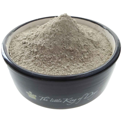 Eine dunkelgraue Schüssel mit der Aufschrift „The little King of Dogs“, gefüllt mit hellgrauem, feinpudrigem Pulver, das kuppelförmig aufgeschüttet ist.