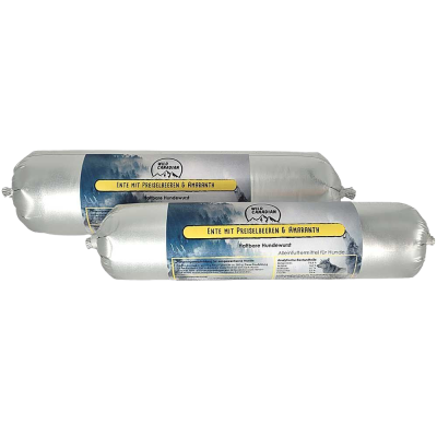 Zwei haltbare Hundewürste in silberner Kunststoffhülle. Das Etikett zeigt die Aufschrift „Ente mit Preiselbeeren & Amaranth“ auf gelbem Hintergrund mit Bergmotiv.