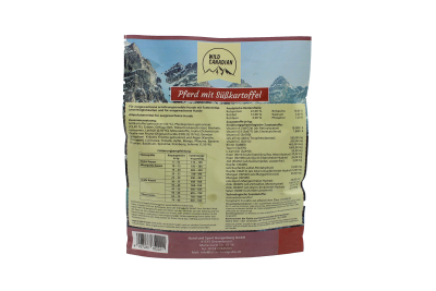 Eine aufrechte Trockenfutter-Verpackung mit Naturmotiv und Berglandschaft, oben Markenlogo, mittig rotes Titelband, darunter dicht gesetzter Textblock mit Tabellen und Angaben, Rückseitenansicht.