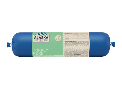 Eine blaue Frostfleischrolle mit mintgrünem Etikett ‚Turkey Pure‘, verpackt in nicht essbarem Kunstdarm; rechts befindet sich ein beiges Informationsetikett mit Text.