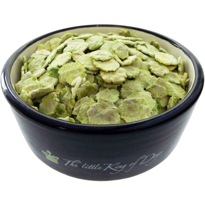 Grünlich-beige Erbsenflocken in flockiger, flach gepresster Form in einem schwarzen Napf mit hellem Innenrand, locker aufgeschichtet.