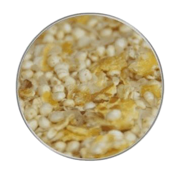 Eine Mischung aus kleinen weißen Körnern und gelblich-beigen Flocken, grob strukturiert und in Nahaufnahme rund eingefasst dargestellt.