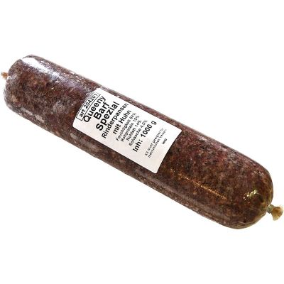 Barf Spezial 1000 g Eine Frostfleischrolle mit weißem Etikett und der Aufschrift „Queeny BARF Spezial Rinderpansen mit Huhn“. Verpackt in einem nicht essbaren Kunstdarm. Die Füllung ist grob gewolft und dunkelbraun gemasert.