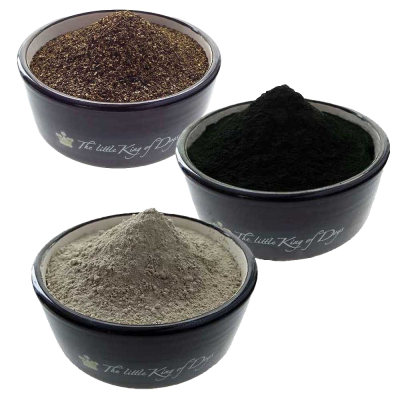 Drei dunkelgraue Schüsseln mit der Aufschrift „The little King of Dogs“, jeweils gefüllt mit verschiedenfarbigem Pulver: braun mit grober Struktur, tiefgrün und fein, sowie hellgrau und puderartig.
