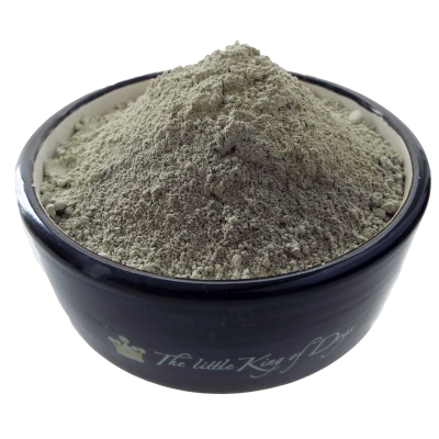 Ein schwarzer Keramiknapf, gefüllt mit einem kegelförmig aufgeschütteten, hellgrauen Pulver mit feiner, leicht unregelmäßiger Struktur und mattem Erscheinungsbild.