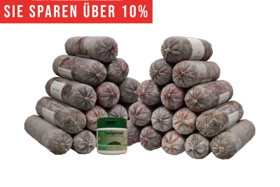 Zwei Pyramiden aus gefrorenen Frostfleischrollen in grauem Kunstdarm mit sichtbaren Etiketten. Davor steht ein weißer Kunststoffbehälter mit grünem Deckel und der Aufschrift „Seealgenmehl“.