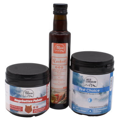 Drei Wild-Canadian-Produkte: eine braune Glasflasche mit Lachsöl in der Mitte, flankiert von zwei schwarzen Kunststoffdosen mit blauem und rotem Etikett für First Choice und Hagebutten Pulver.