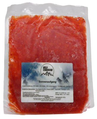 Ein flacher, transparenter Kunststoffbeutel mit leuchtend rotem, fein zerkleinertem Inhalt. Die Oberfläche zeigt eine leicht unregelmäßige, breiige Struktur.