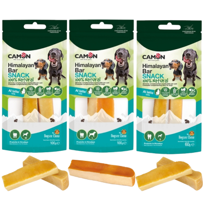 Drei grün-weiße Verpackungen mit Hundesnacks, davor je zwei bis drei harte Riegel in beige mit gelb-orangefarbener Oberfläche, teils gerade, teils gebogen und übereinanderliegend.