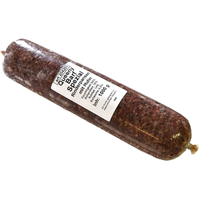Eine Frostfleischrolle mit weißem Etikett und der Aufschrift „Queeny BARF Spezial Rinderpansen mit Huhn“. Verpackt in einem nicht essbaren Kunstdarm. Die Füllung ist grob gewolft und dunkelbraun gemasert.