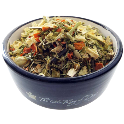 Ein Napf mit einer groben, hellgrünen und orangefarbenen Trockenmischung aus Blättern, Stängeln und kleinen Gemüseflocken. Die Struktur wirkt locker und naturbelassen.