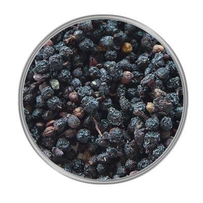 Getrocknete, dunkelviolette Beeren in Nahaufnahme, kreisförmig angeordnet auf weißem Untergrund. Die Oberfläche wirkt runzlig und leicht glänzend.