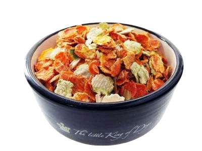 Eine dunkelblaue Futterschale mit bunter Gemüseflockenmischung aus groben, getrockneten Scheiben in Orange, Hellgrün, Beige und Gelb, überwiegend flach und gewölbt.